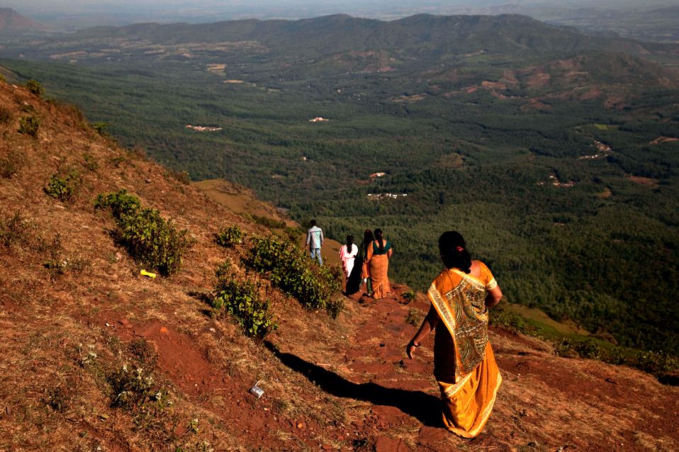 Visitors walk near a Hindu temple that sits atop the highest peak of the Bababudan Giris.