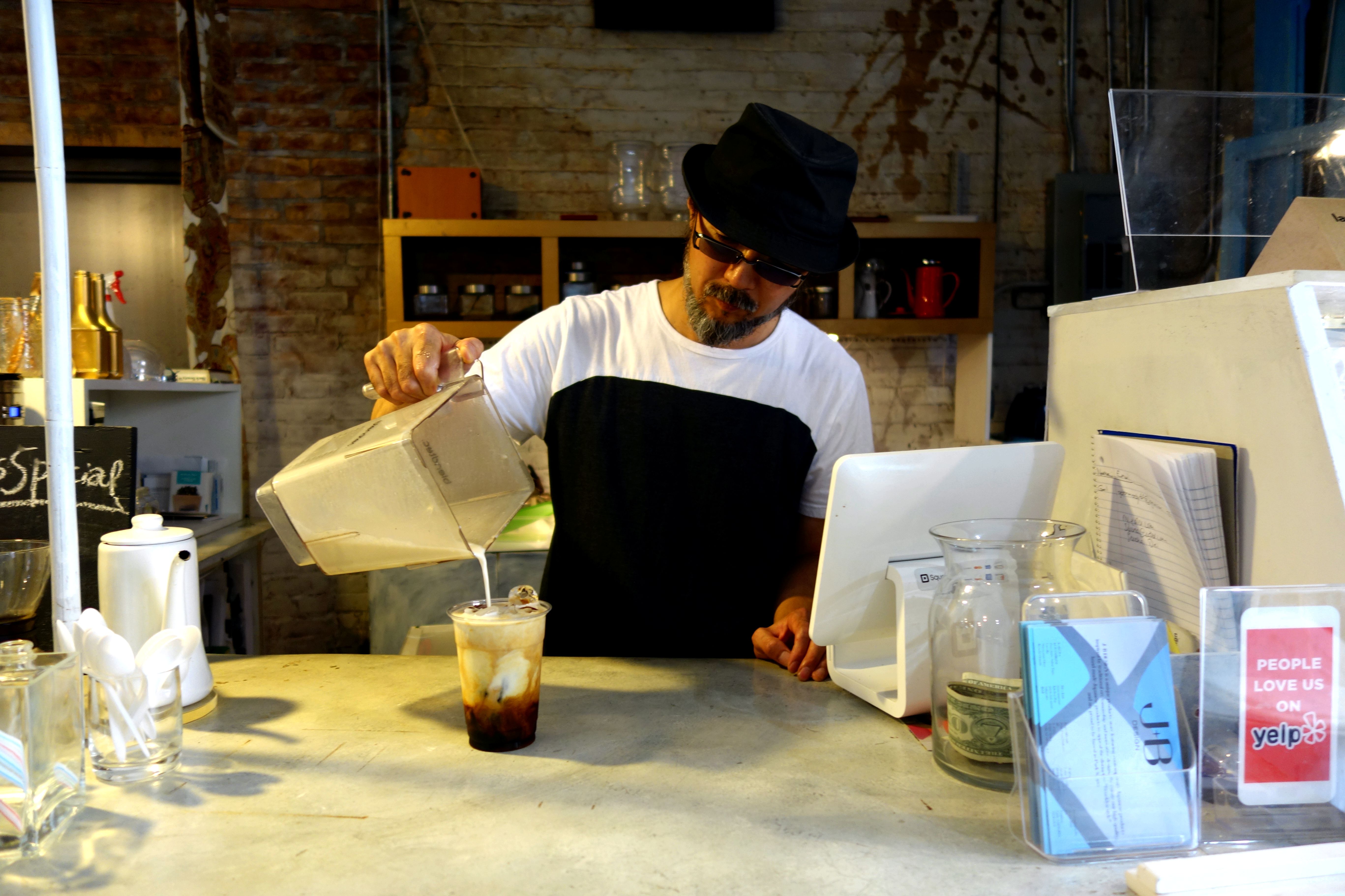 Fumio Tashiro pouring banana milk on coffee