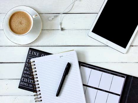Black Pen on White Writing Spring Notebook Between White Ipad and White Ceramic Mug With Latte on White Plate